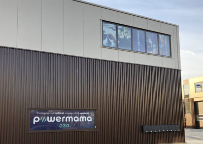 Bedrijfspand voorzien van kleurrijke raamstickers en groot reclamebord